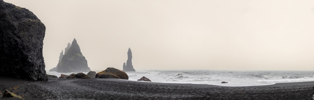 Una spiaggia rocciosa con una grande roccia che spunta dall'acqua