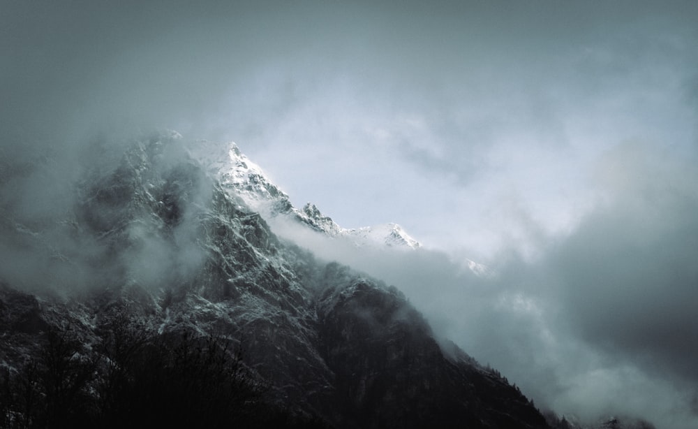 una montaña muy alta cubierta de nieve bajo un cielo nublado