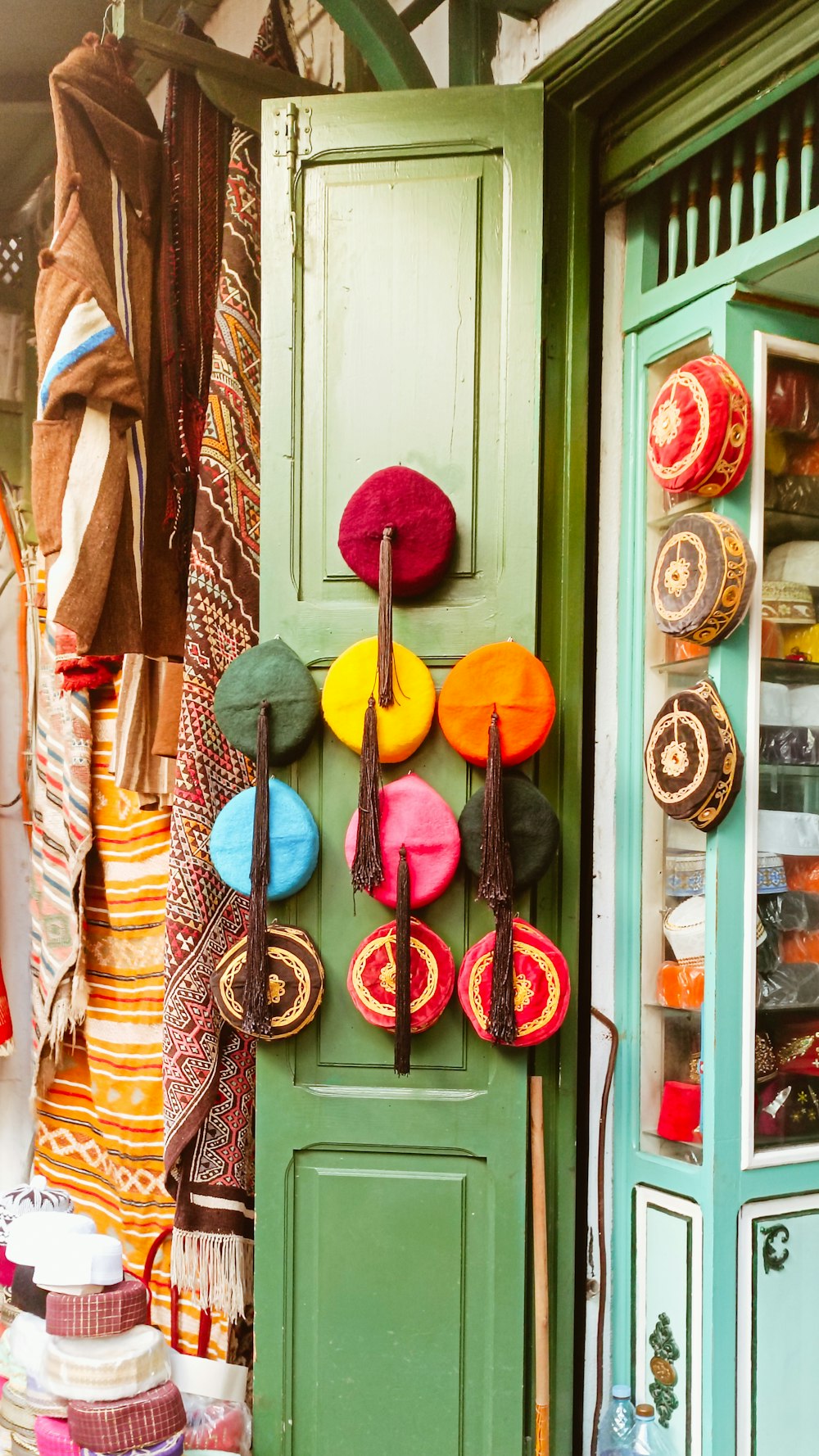 a green door with a bunch of hats hanging on it