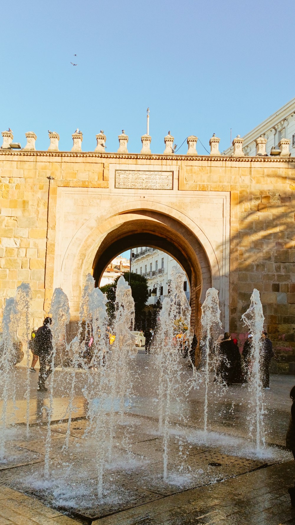 a group of people standing around a fountain