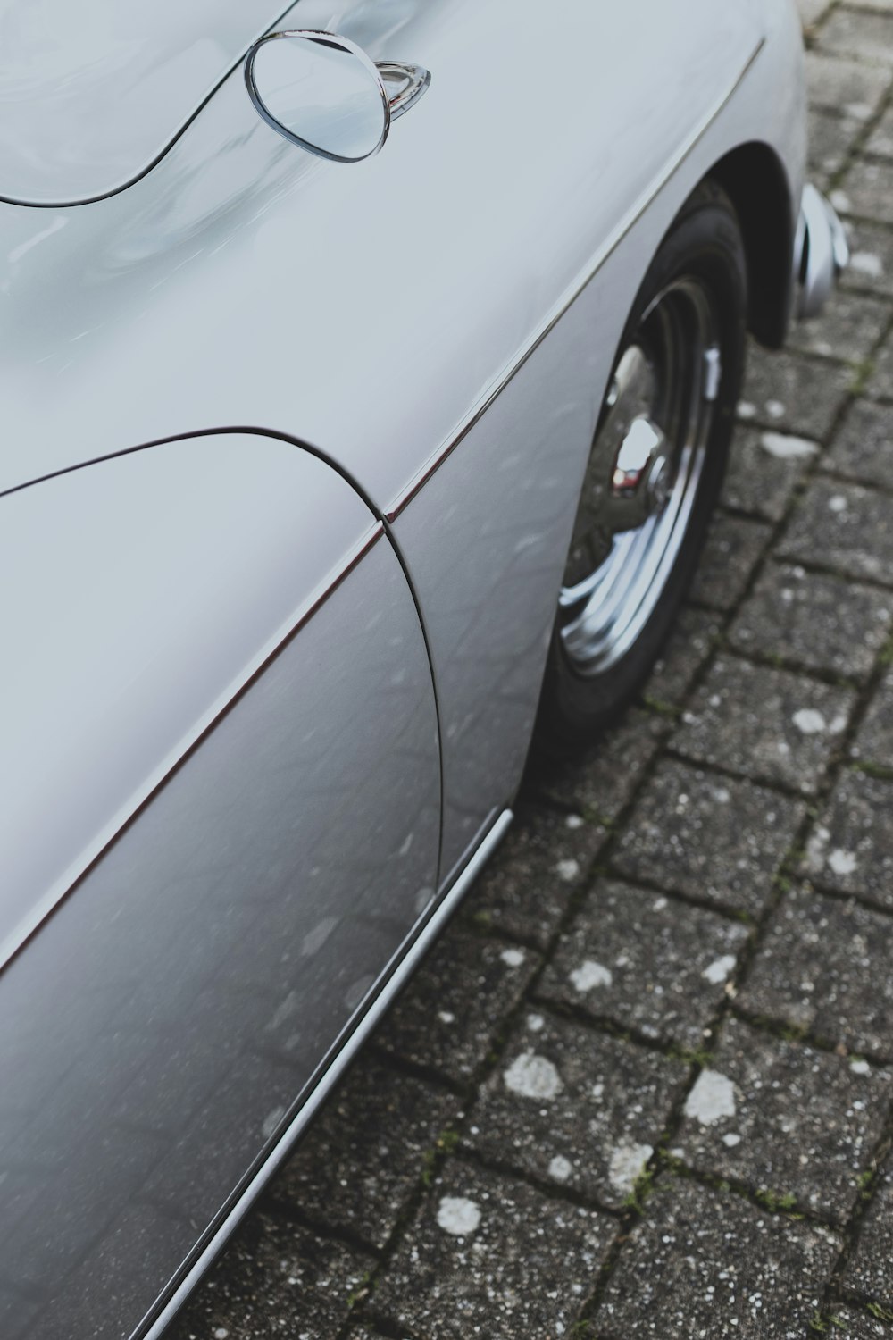 a close up of a car parked on a brick road