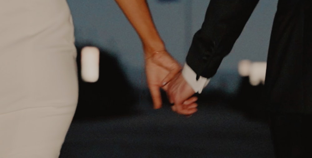 a close up of two people holding hands