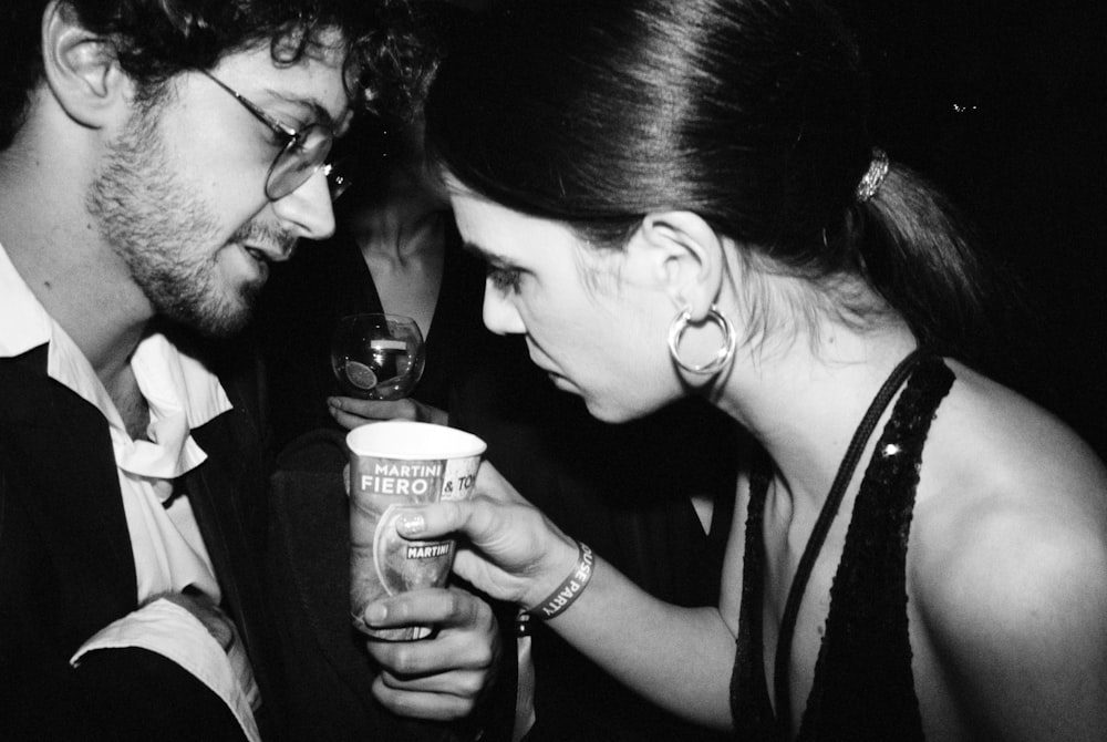 a man and a woman holding a drink together