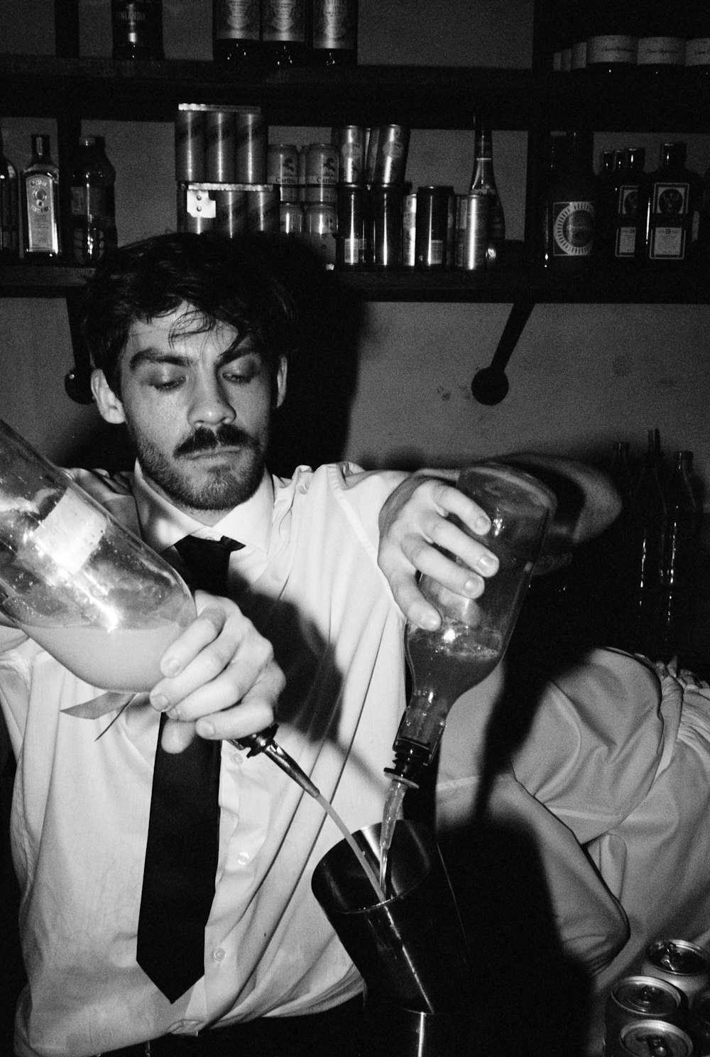 a man pouring a drink into a glass