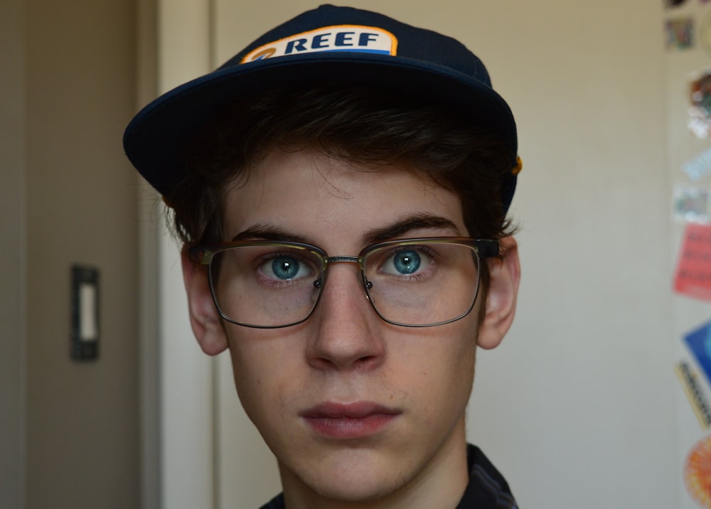 a young man wearing a hat and glasses