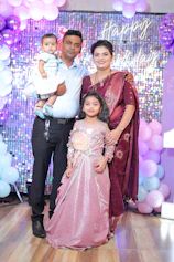 a family posing for a picture in front of balloons