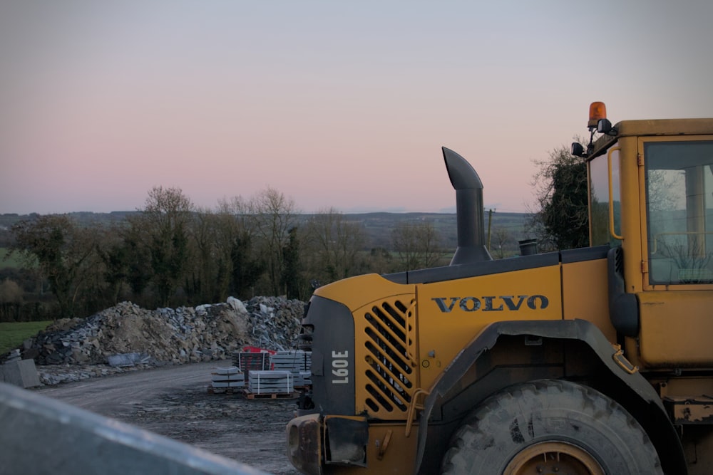 a large yellow bulldozer parked on top of a dirt road