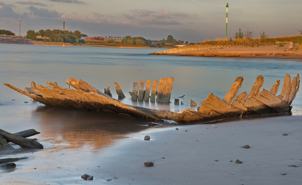 a boat sitting on top of a beach next to a body of water