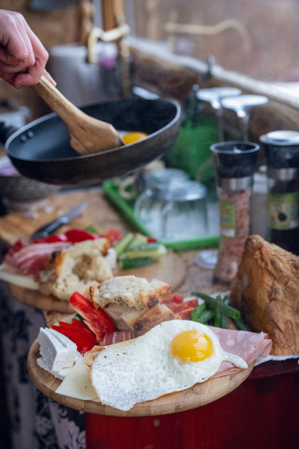 a person holding a wooden spoon over a plate of food