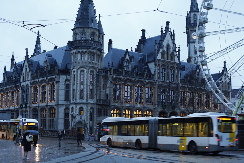 a couple of buses that are sitting in front of a building