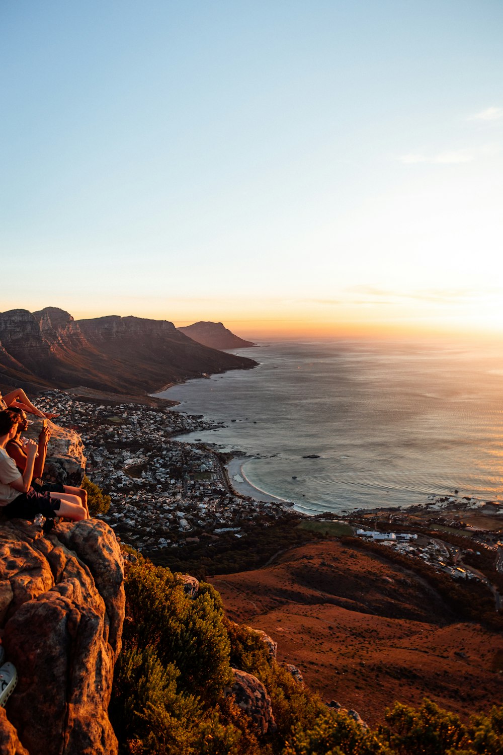 a couple of people sitting on top of a mountain