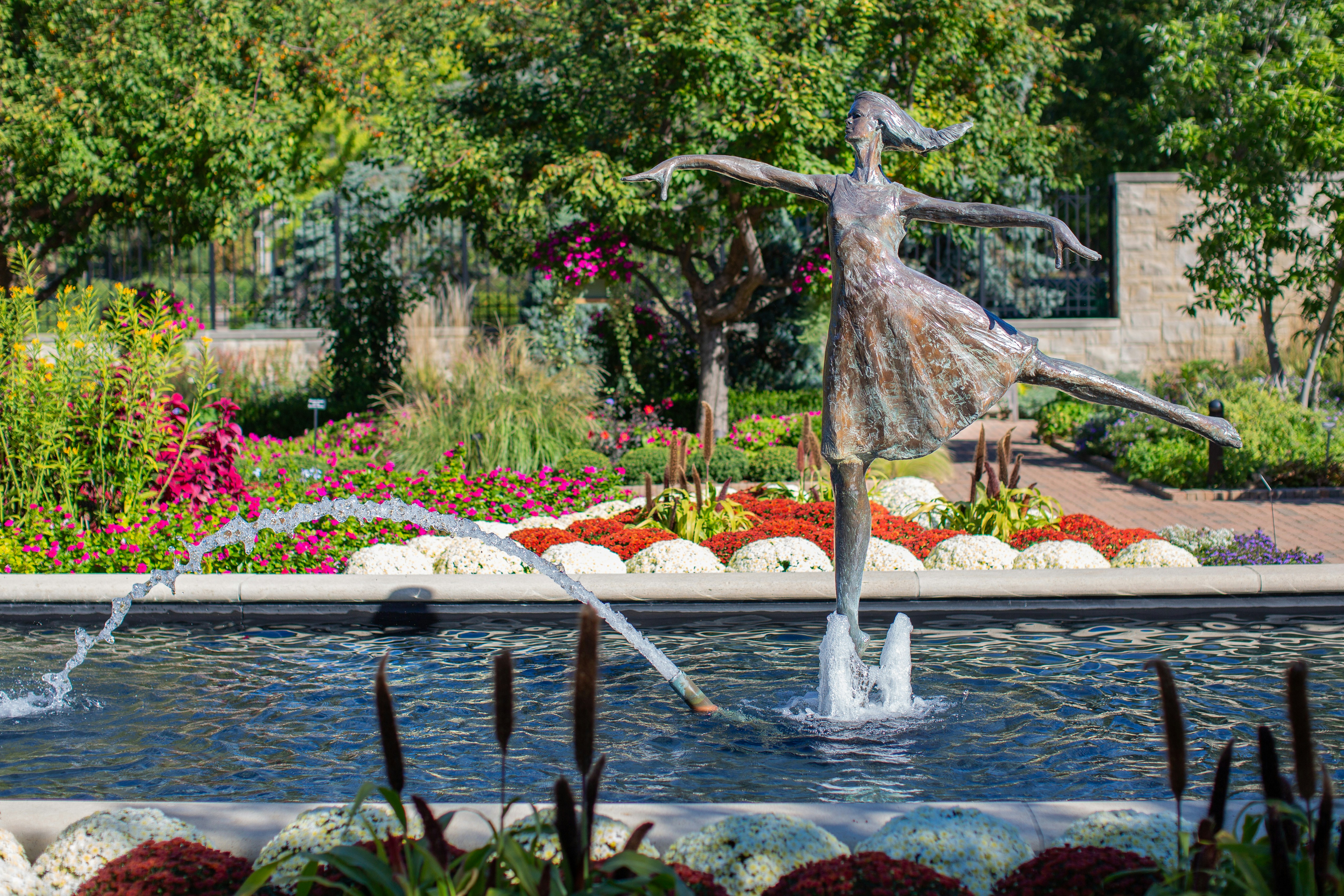 a statue of a woman dancing in a garden