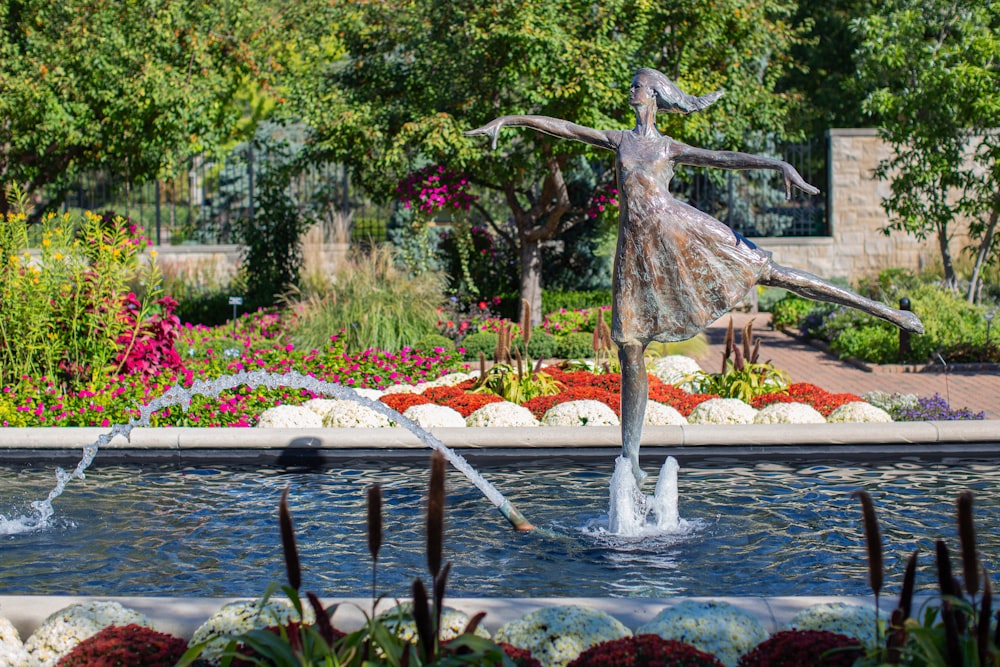 a statue of a woman dancing in a garden