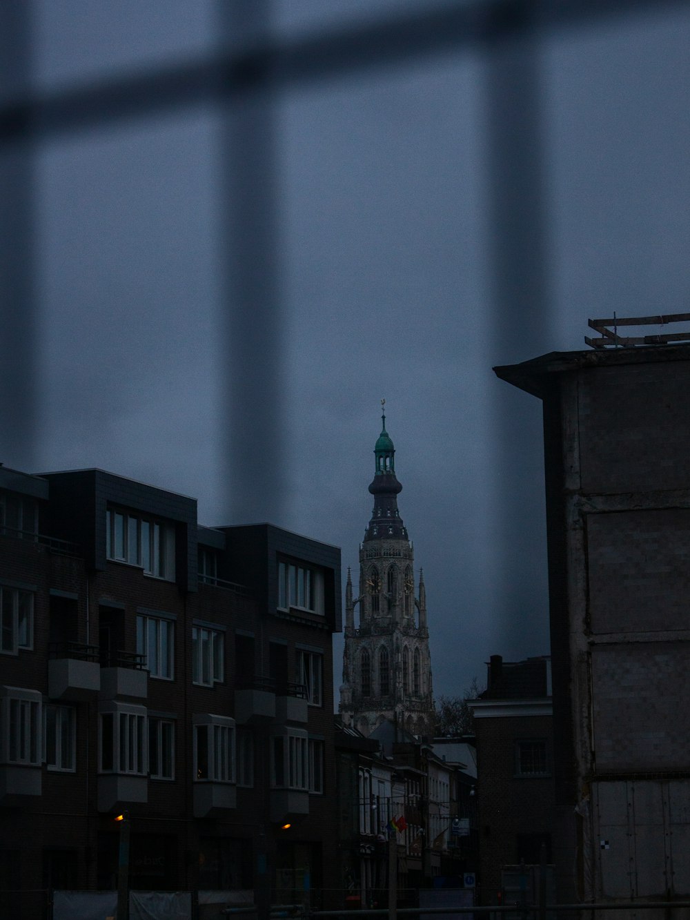 a view of a clock tower through a fence