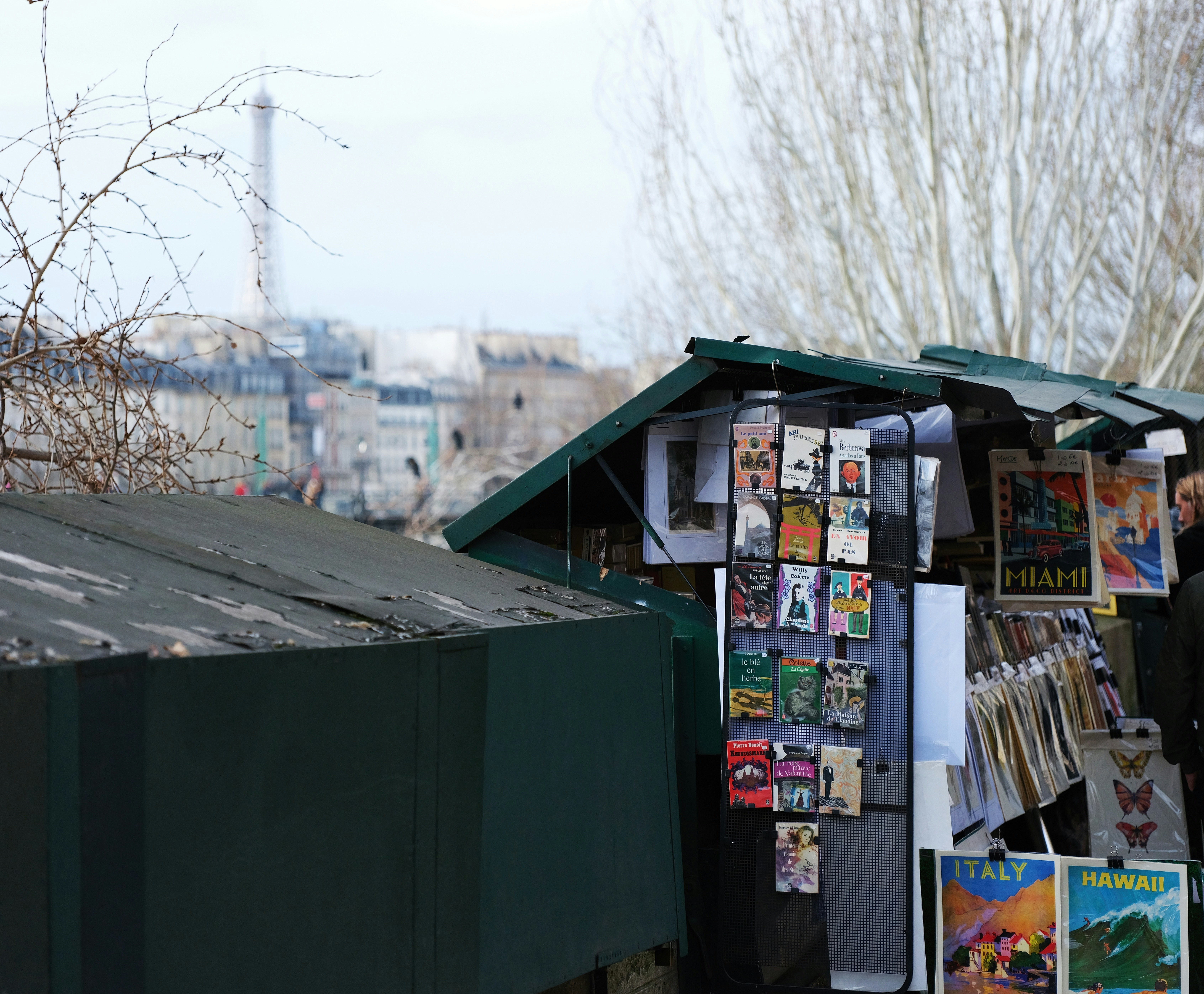 a man standing next to a green shed with posters on it
