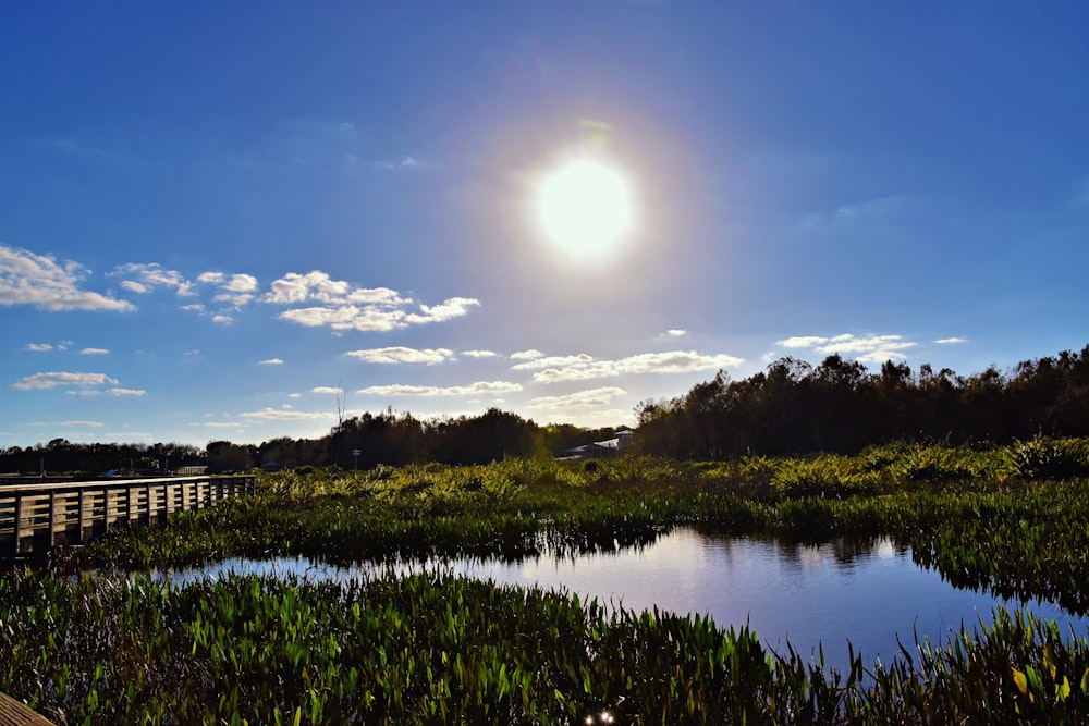 the sun is shining over a small lake