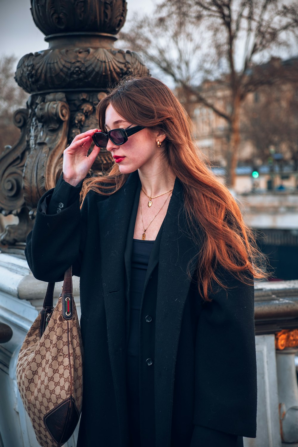 a woman in a black coat and sunglasses