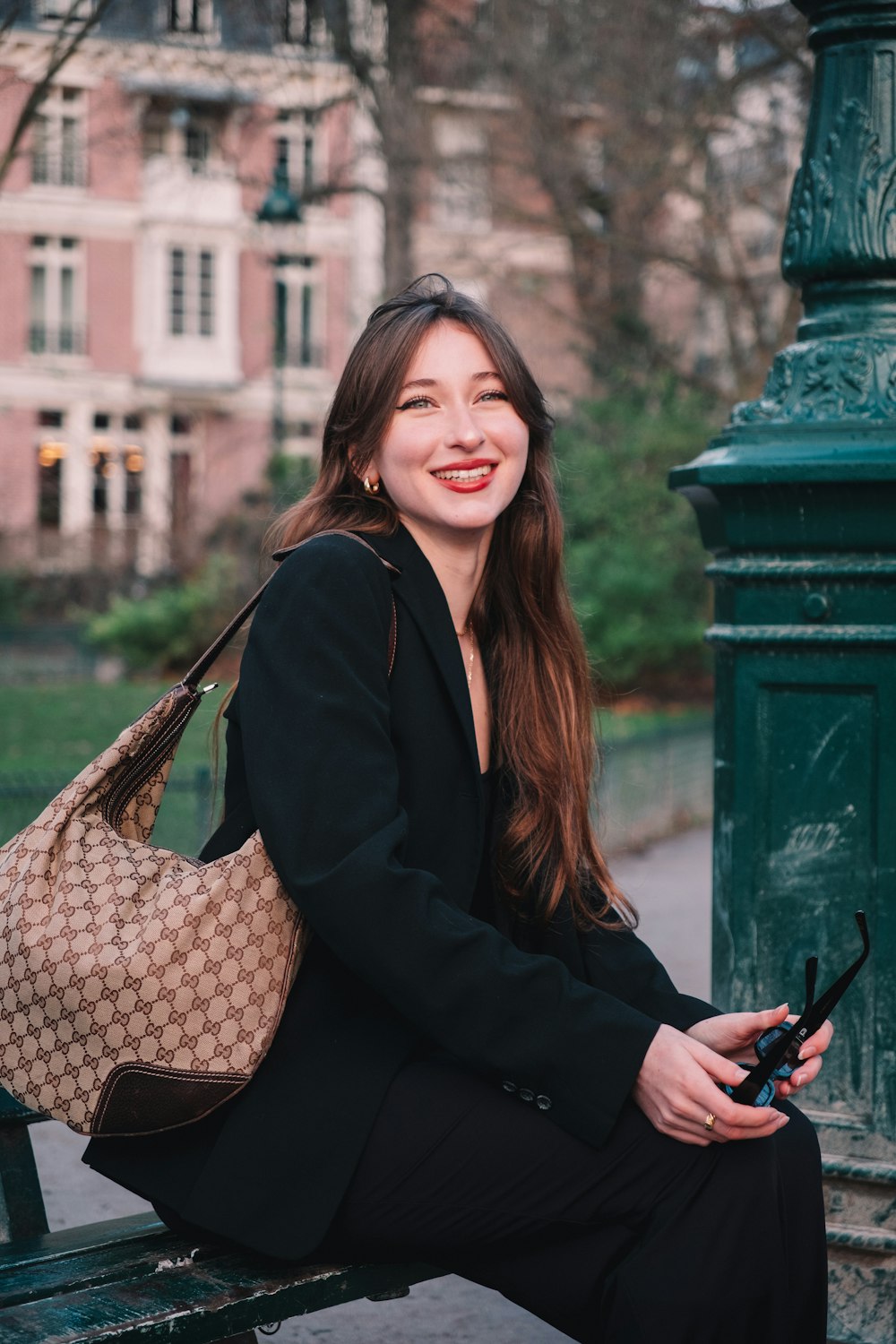 a woman sitting on a bench holding a purse