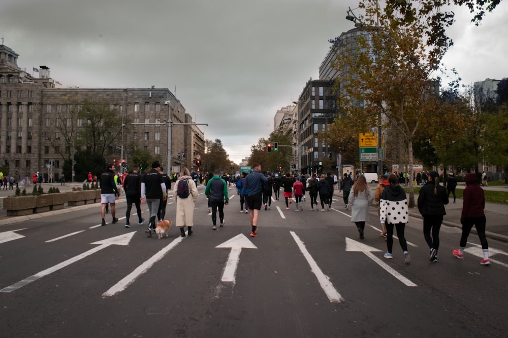 a group of people walking across a street