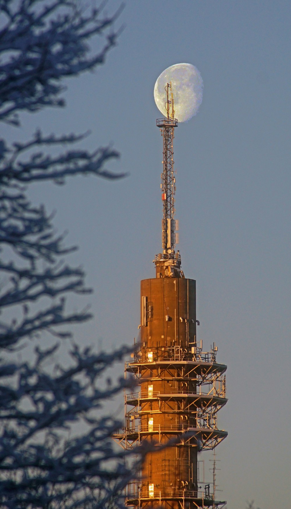 a very tall tower with a very large moon on top of it