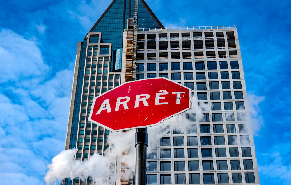 a red stop sign sitting in front of a tall building