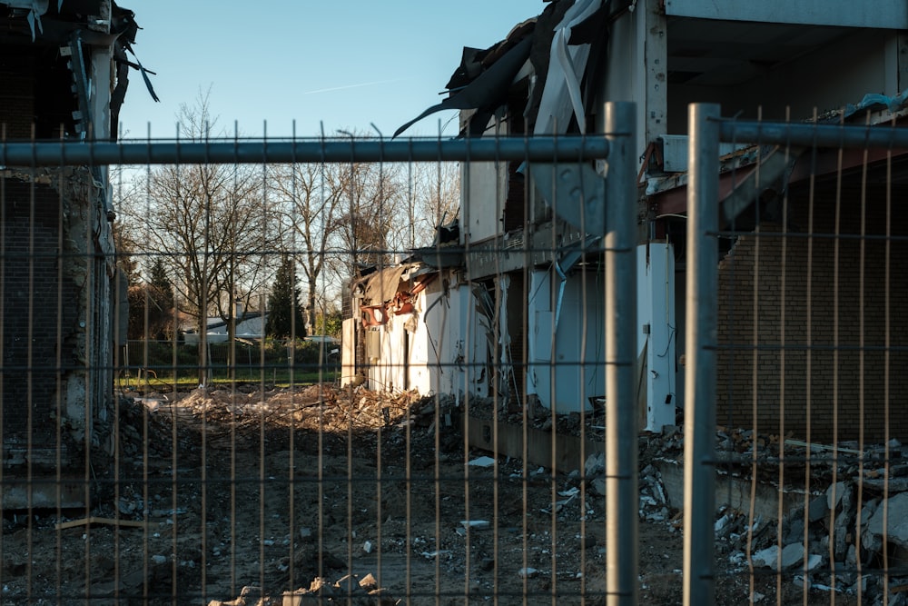 a building with a bunch of rubble behind a fence