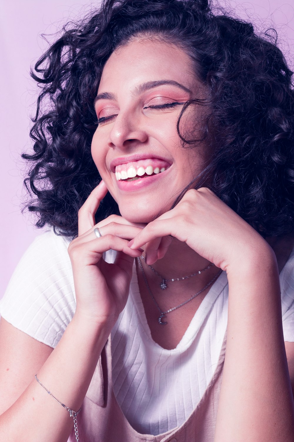 a woman with curly hair is smiling and posing for a picture