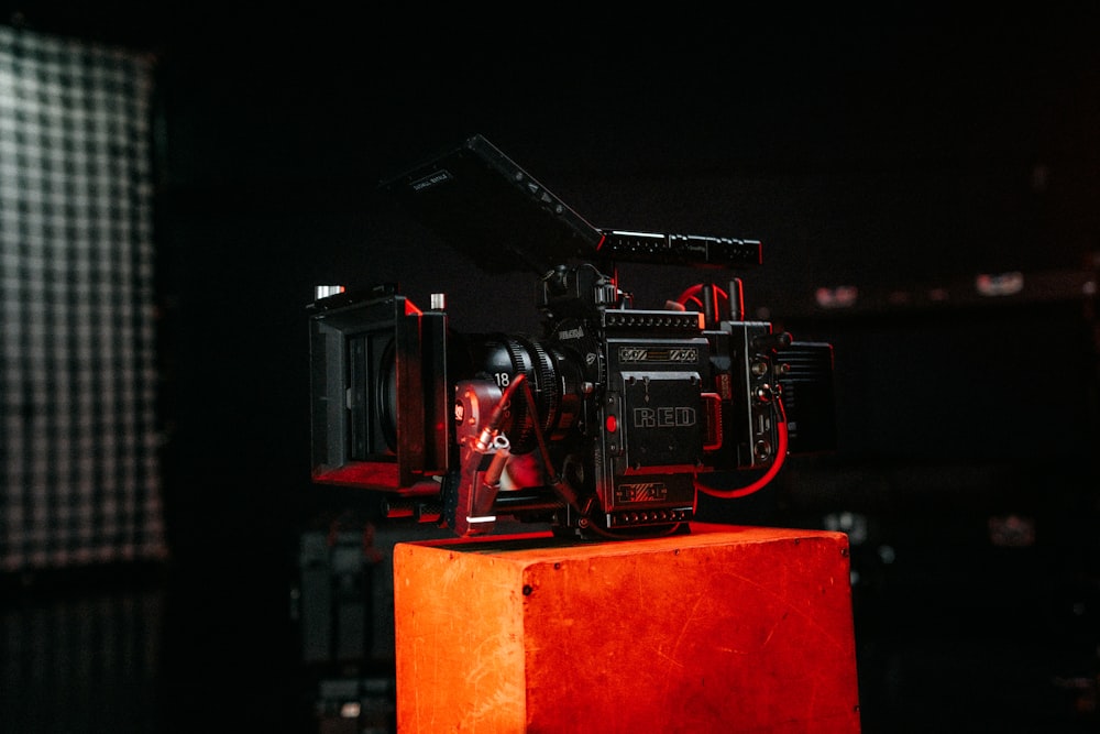 a red camera sitting on top of a wooden block