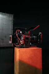 a red camera sitting on top of a wooden box