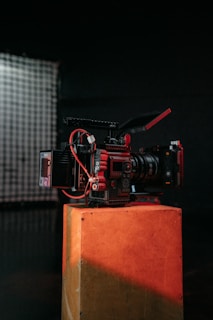 a red camera sitting on top of a wooden box