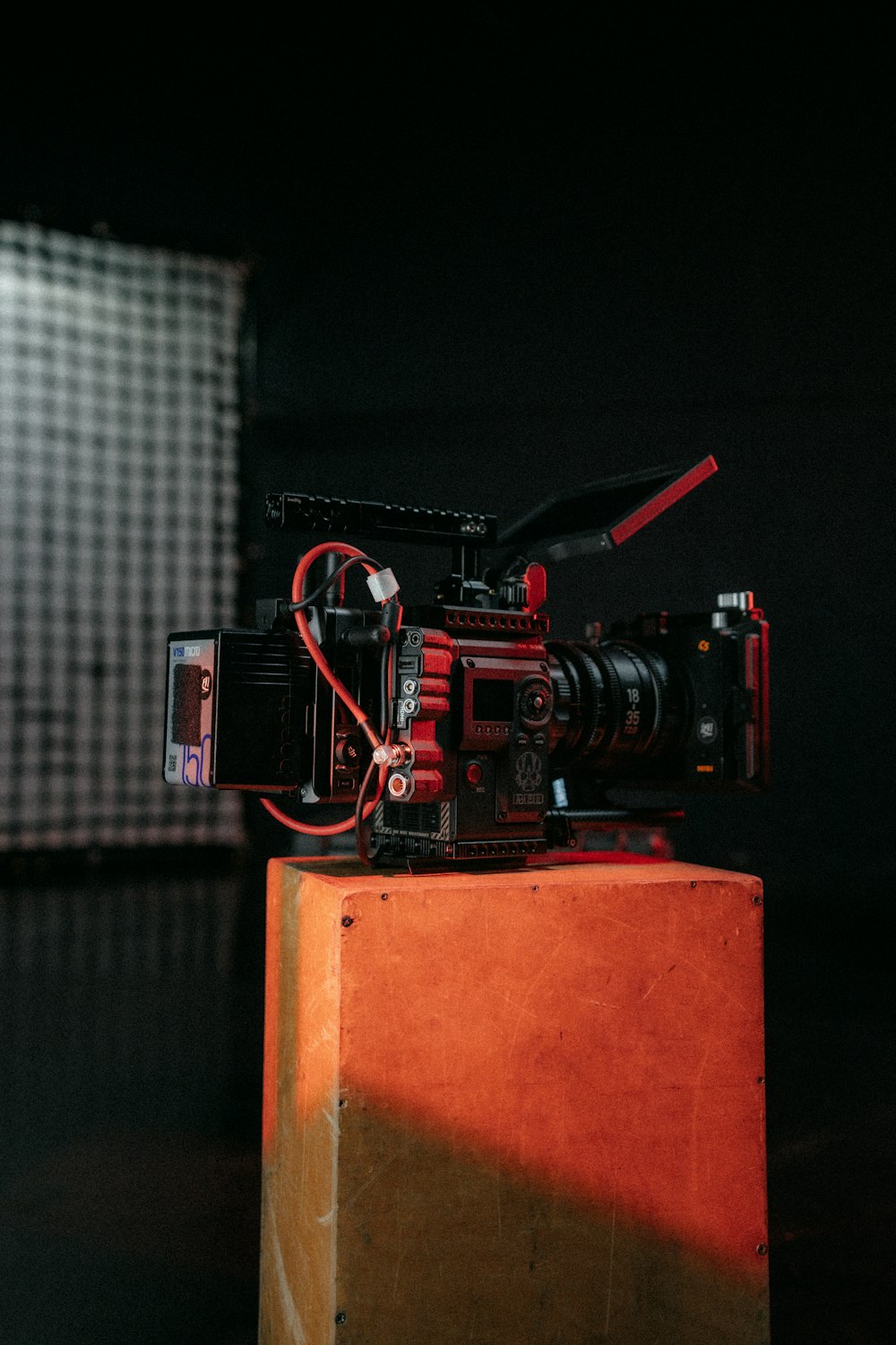 una cámara roja encima de una caja de madera
