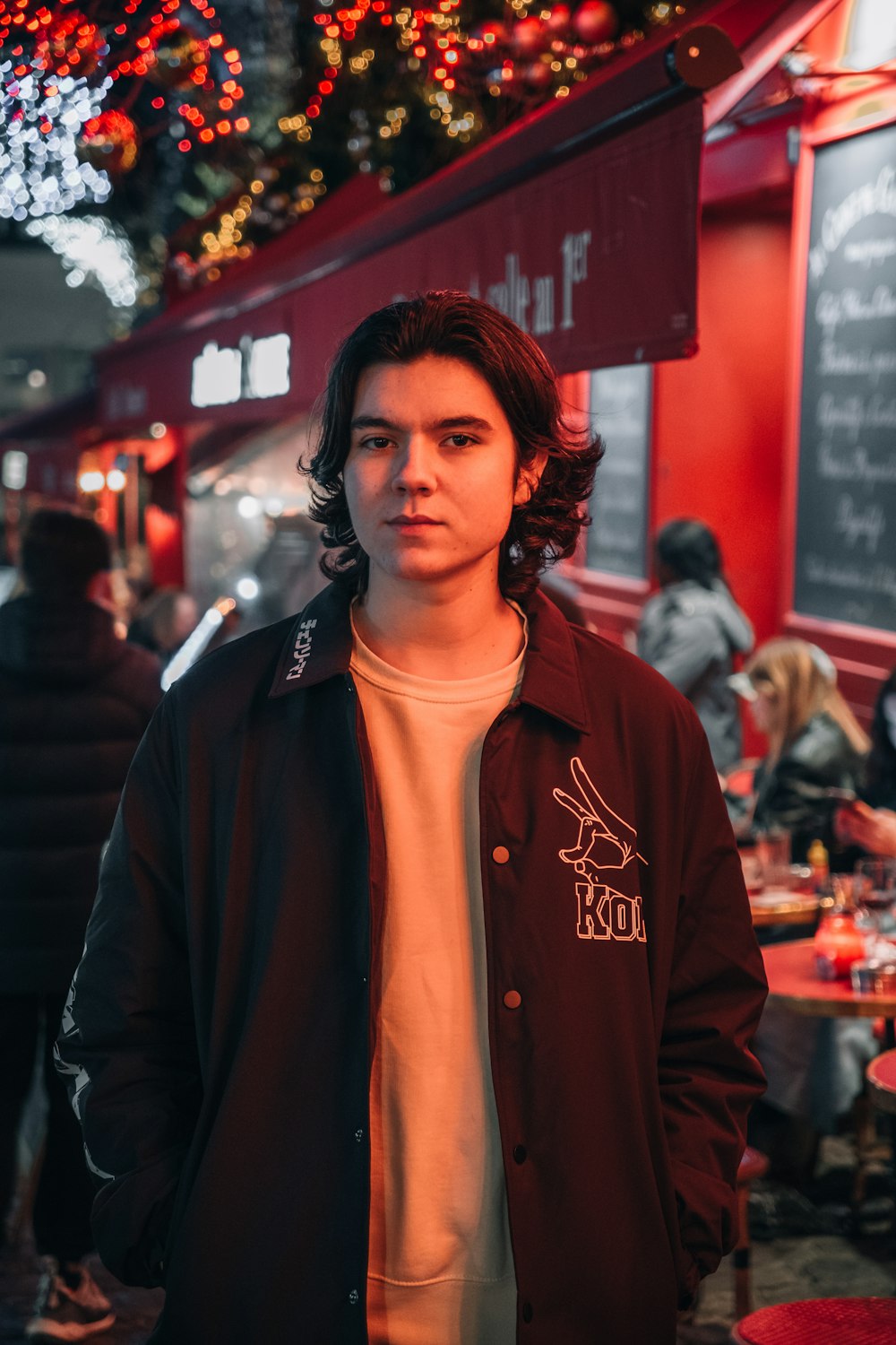 a young man standing in front of a restaurant