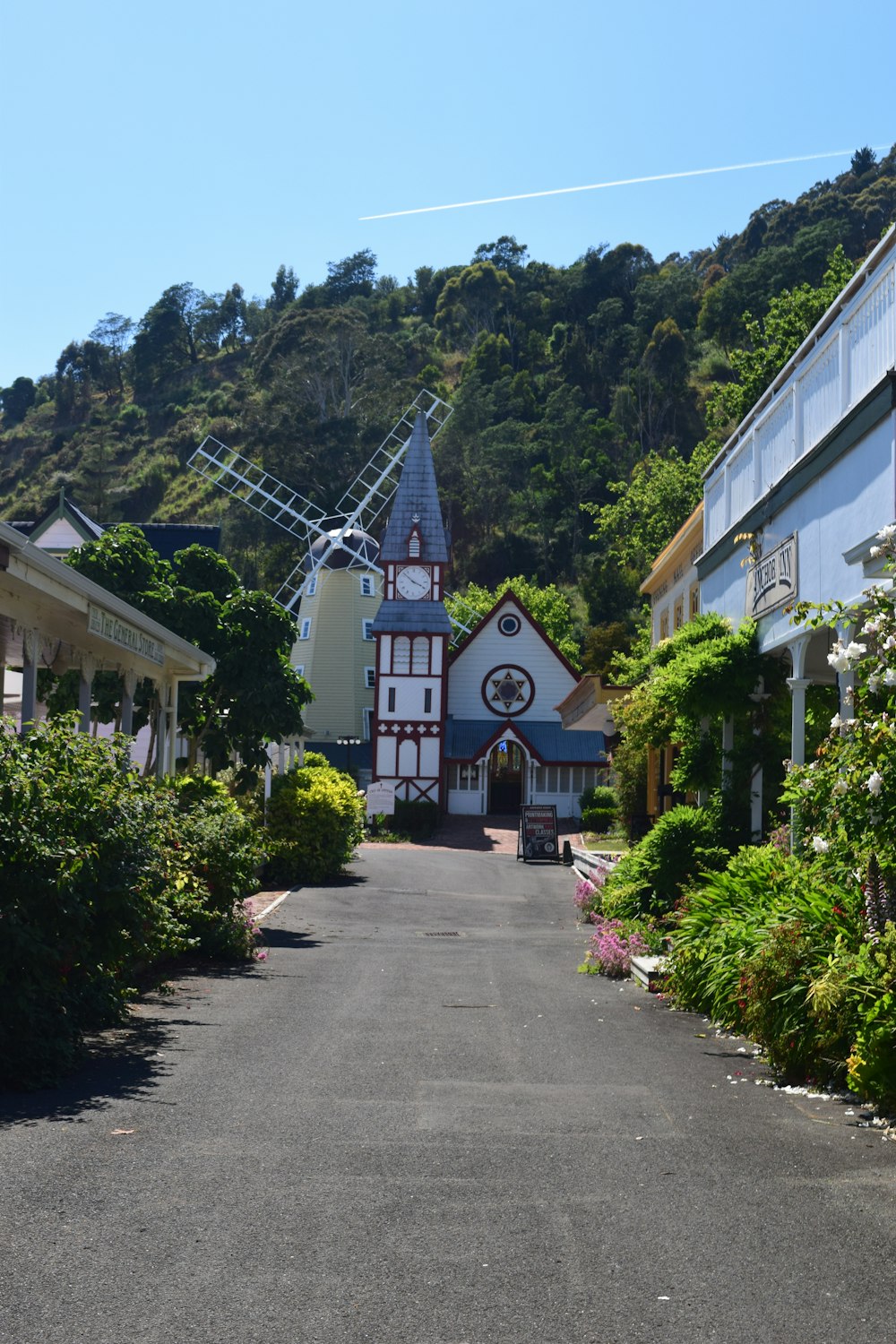 a street with buildings and a windmill in the background