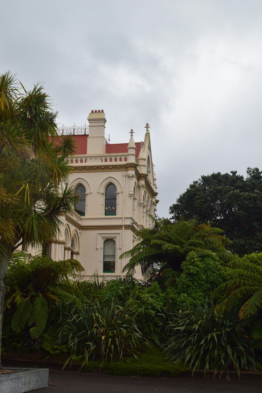 a large white building surrounded by trees and bushes