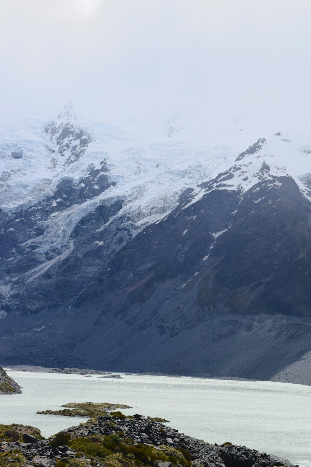 a mountain range with a body of water in the foreground