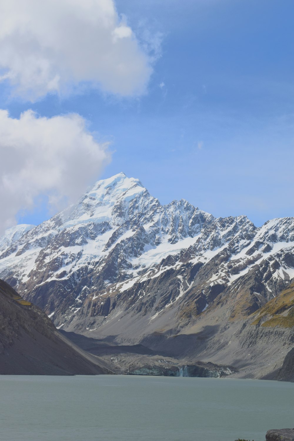 a mountain range with a lake in the foreground