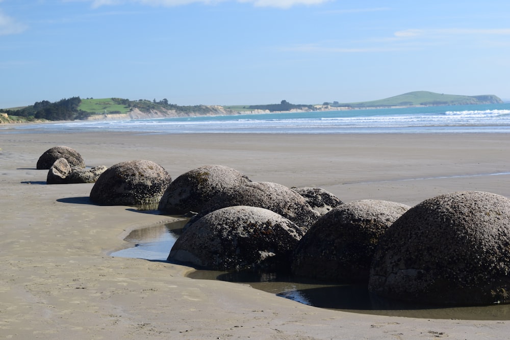 a group of large rocks sitting on top of a sandy beach