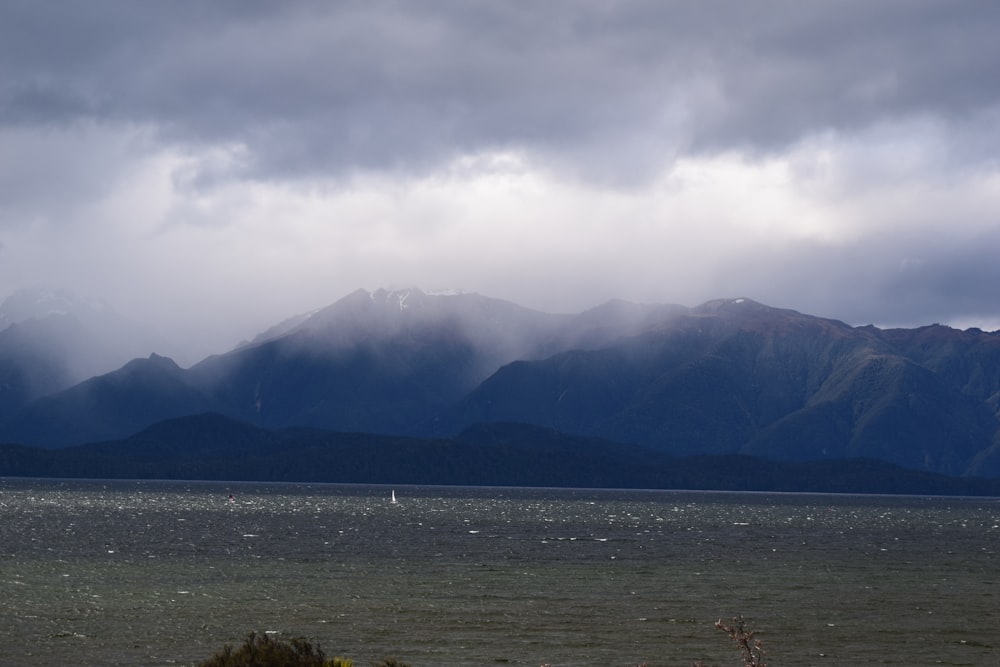 a large body of water with mountains in the background