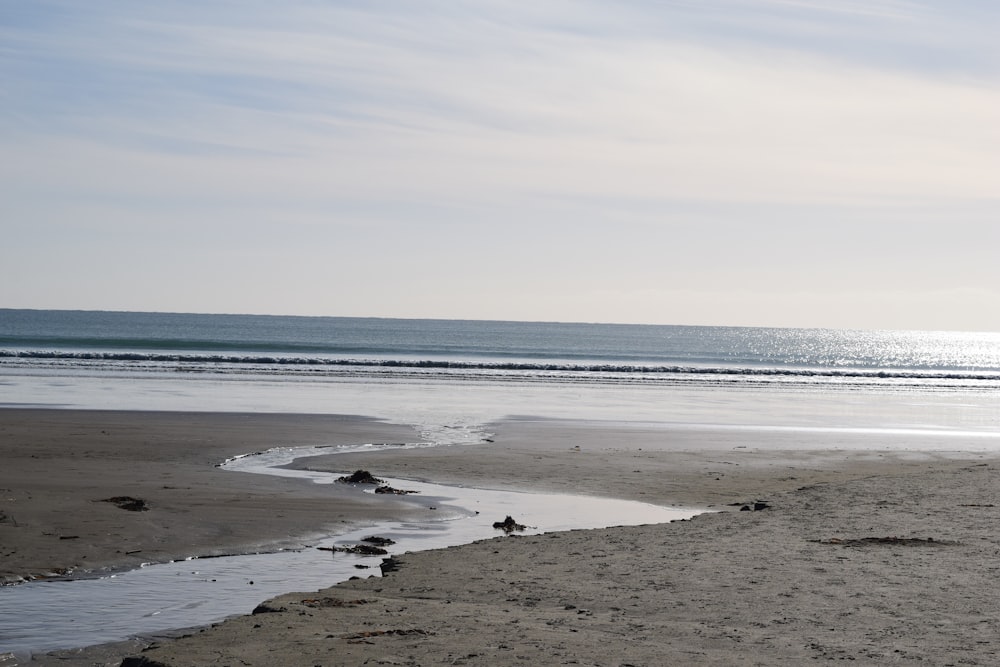 a person walking on a beach with a surfboard