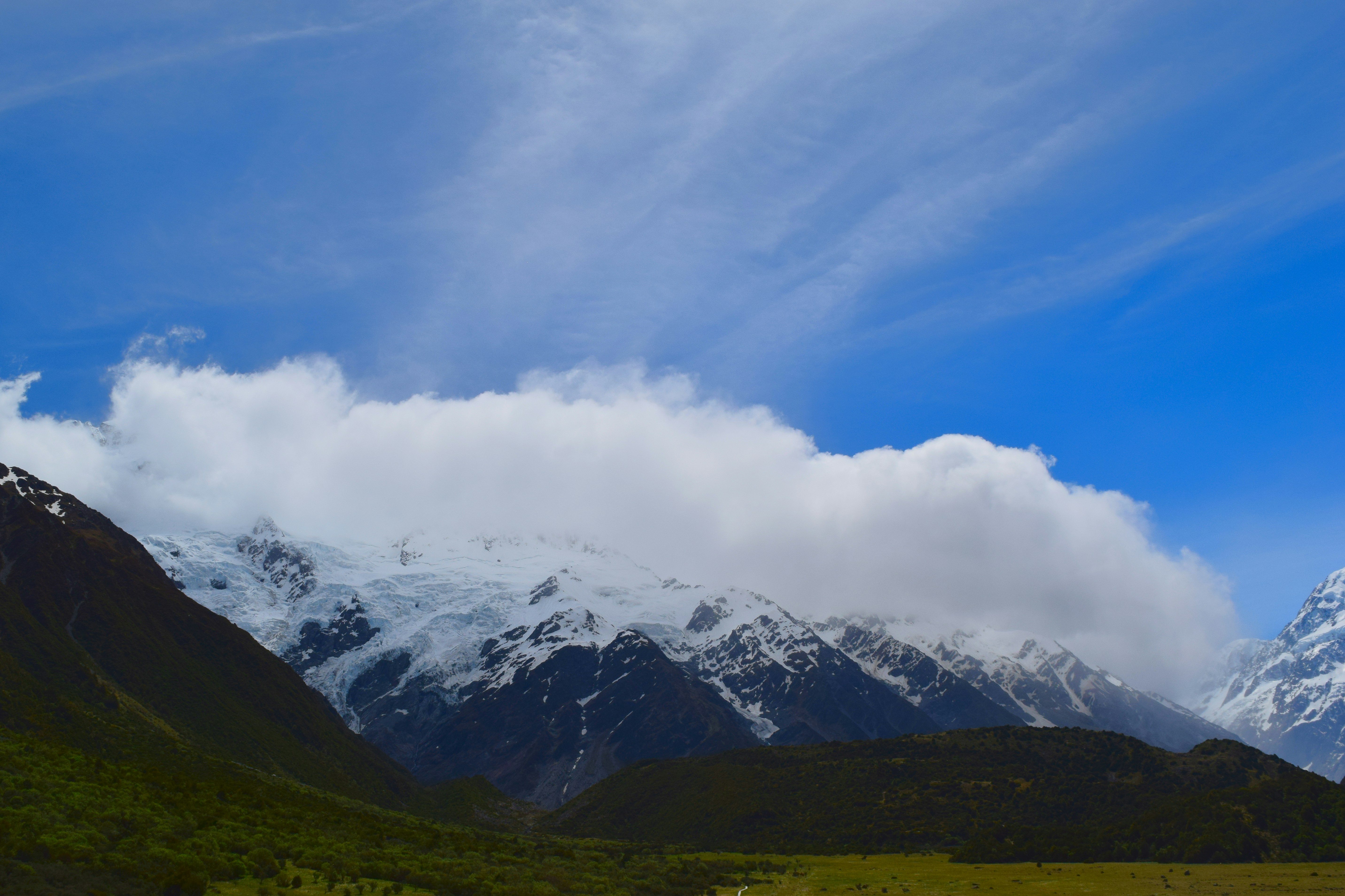 a mountain range with snow capped mountains in the background, 
