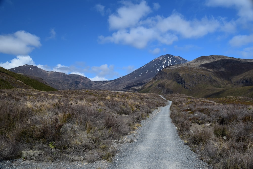 a dirt road with a mountain in the background