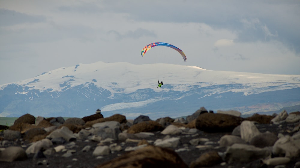 a person is parasailing on a rocky beach