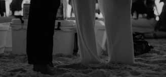 a couple of people that are standing in the sand