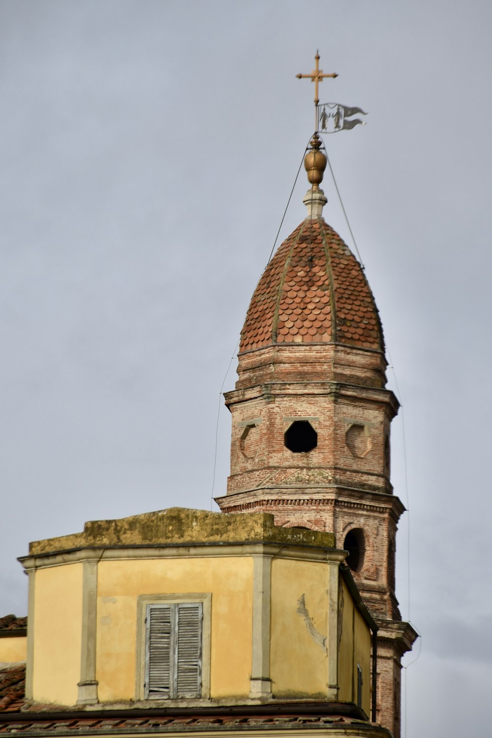 uma torre alta com uma cruz em cima dela