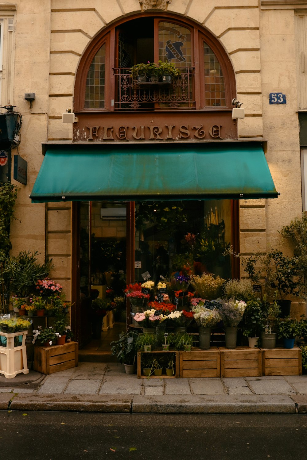 a flower shop with a green awning on the front of it