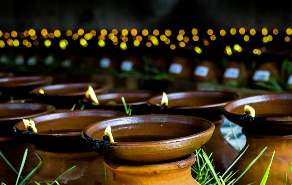 a group of clay pots with lit candles in them