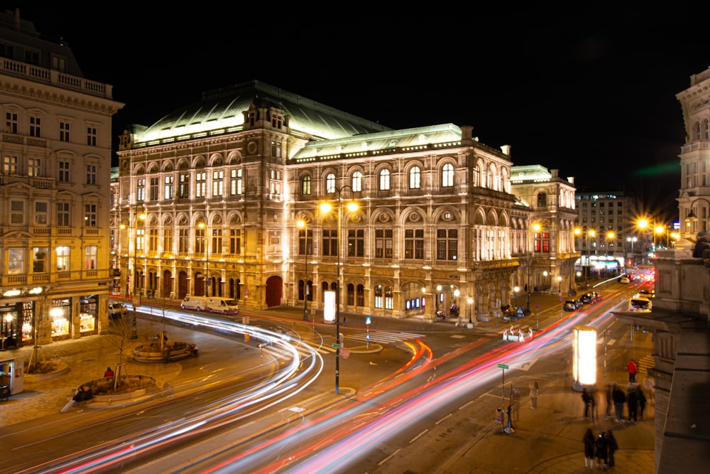 a busy city street at night with a building in the background