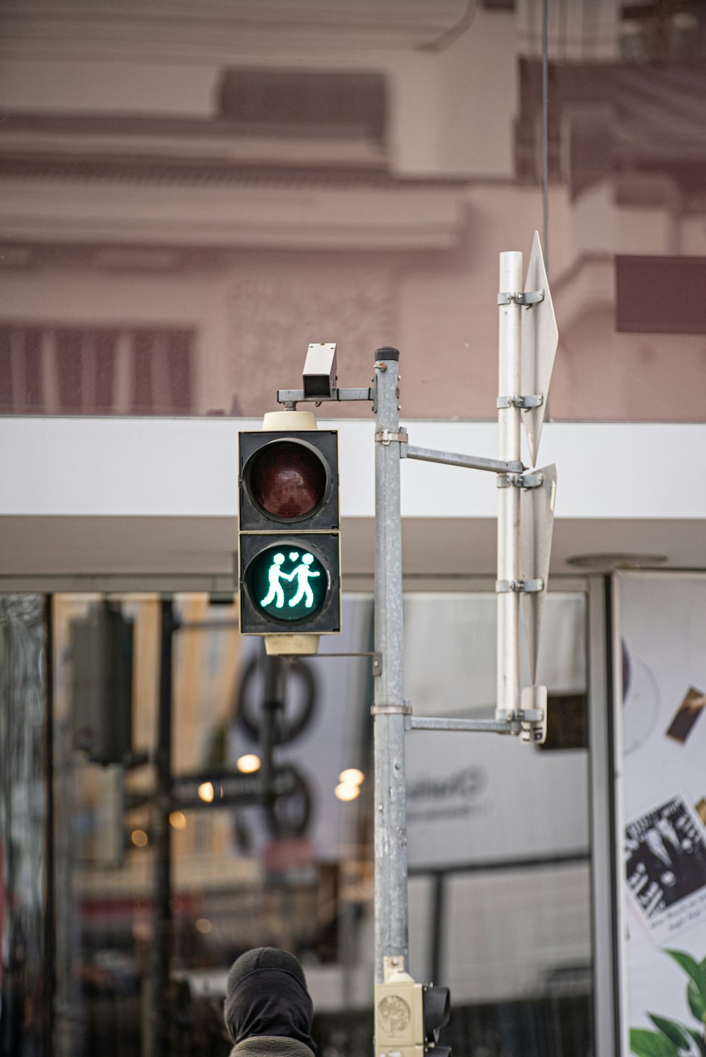 a pedestrian crossing signal in front of a store
