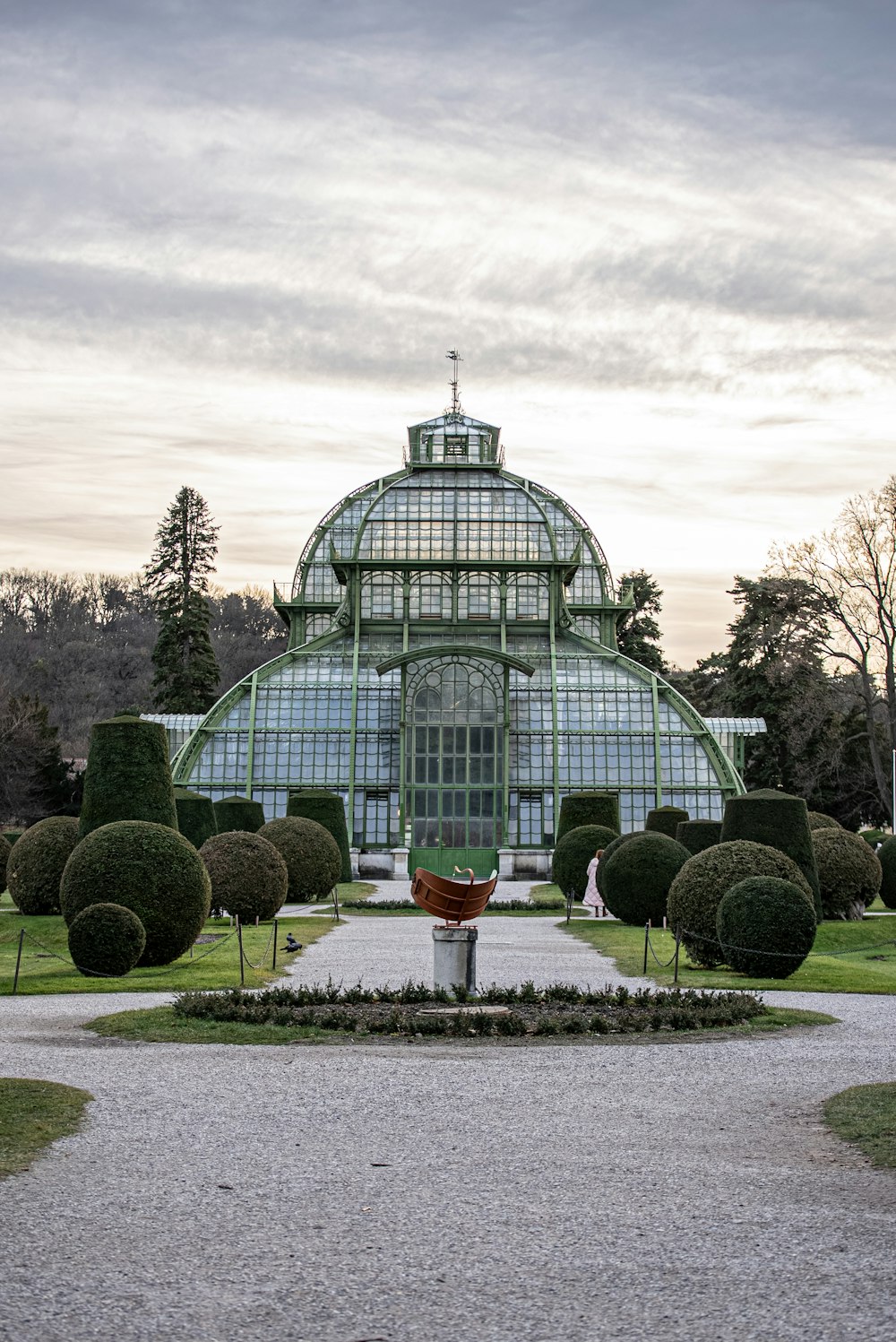 a large glass building with a fountain in the middle of it