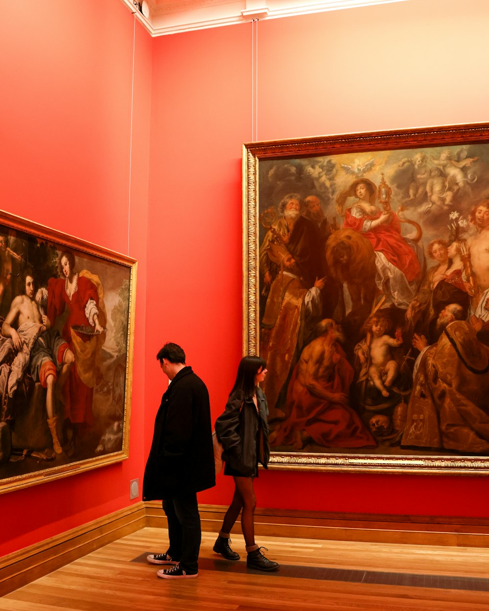 a man and a woman standing in front of a painting